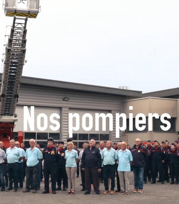 Sapeurs-pompiers posant devant la caserne pour la photo du calendrier